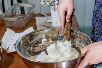 Midsection of woman holding ice cream in kitchen