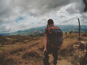 Rear view of man standing on land against sky