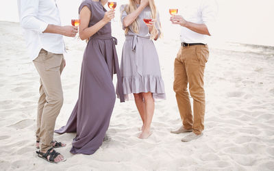 Low section of people standing on beach