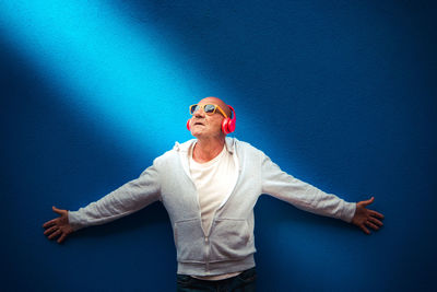 Portrait of woman standing against blue wall