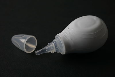 Close-up of bottle on table against black background