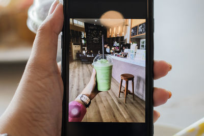 Midsection of person holding drink at restaurant table