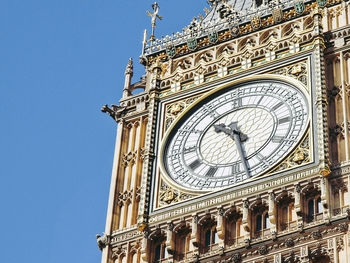 Low angle view of clock tower against blue sky