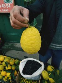 Midsection of man holding fruits in market