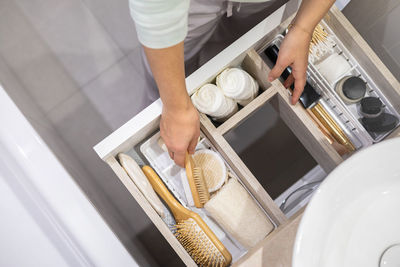 Midsection of woman arranging combs in drawer