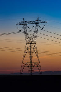 Low angle view of silhouette electricity pylon against sky during sunset