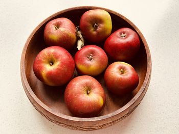 Seven apples in wooden dish. red and green apples. foraged in community orchard. fresh and juicy.