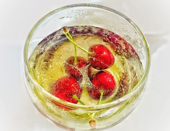 Close-up of cherry drink in glass on white background