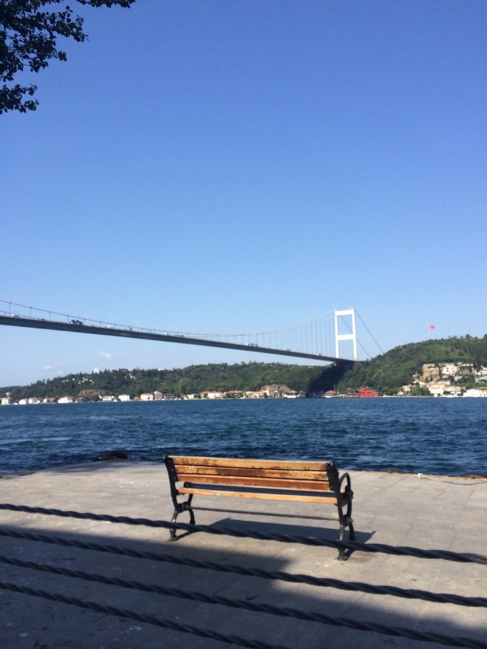 clear sky, copy space, full length, water, lifestyles, railing, leisure activity, rear view, men, walking, person, blue, connection, standing, built structure, river, bridge - man made structure, architecture