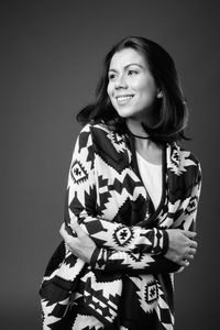 Smiling young woman against black background