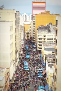 Crowd on street in city against sky