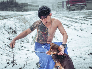 Full length of shirtless man with dog
