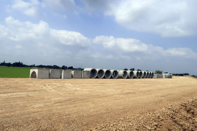 Hay bales on field against sky