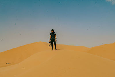 Rear view of man in desert against sky