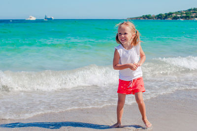 Portrait of young woman standing at beach