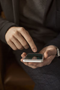 Midsection of man using mobile phone