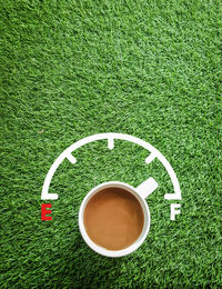 High angle view of coffee cup on grass