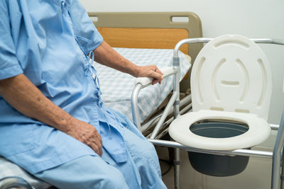 Flush toilet and shower chair in bathroom for old elder people.