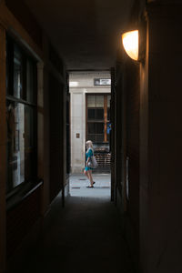 Side view of man walking in corridor of building