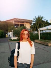 Portrait of young woman wearing sunglasses standing outdoors