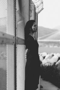 Young woman standing against the sky