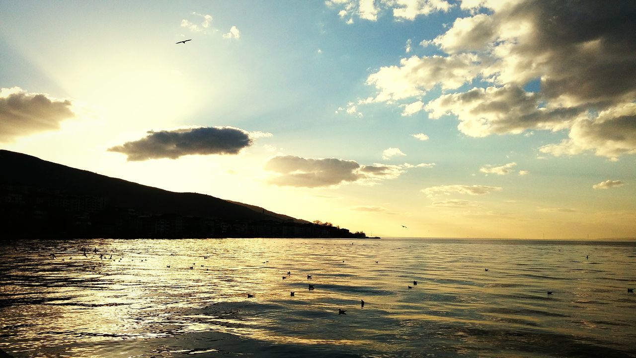 water, sea, tranquil scene, scenics, sky, tranquility, sunset, beauty in nature, silhouette, waterfront, horizon over water, nature, rippled, idyllic, cloud - sky, sun, bird, cloud, flying, reflection