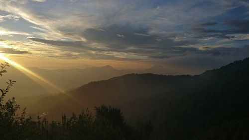 Scenic view of silhouette mountains against sky at sunset