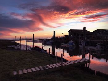 Scenic view of river by buildings against dramatic sky