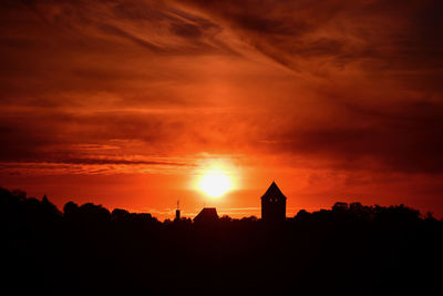 Silhouette buildings against sky during sunset