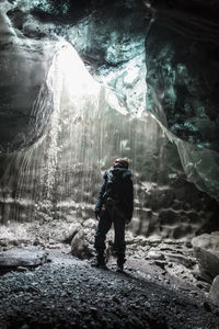 Rear view of man standing in cave