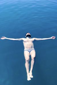 Full length of man floating on water in sea