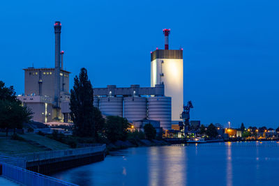 Illuminated buildings against sky at dusk