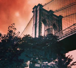 Low angle view of bridge and buildings against sky