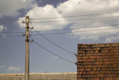 Low angle view of electricity pylon against sky