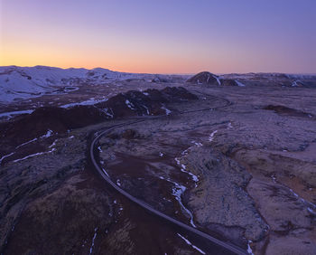 Desert road in rocky terrain during sundown