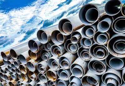 High angle view of stack of pipes on sea against sky