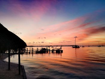 Silhouette pier over sea against sky during sunset