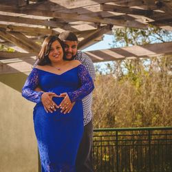 Portrait of smiling man with pregnant woman standing below bridge