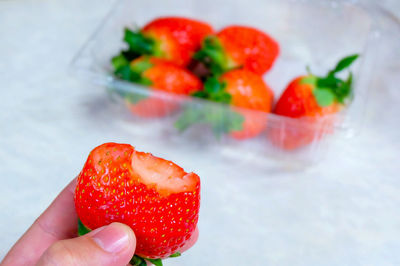 Close-up of cropped hand holding strawberry