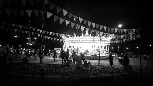 Group of people in amusement park at night