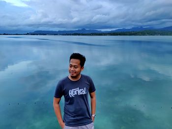 Portrait of smiling young man against sky