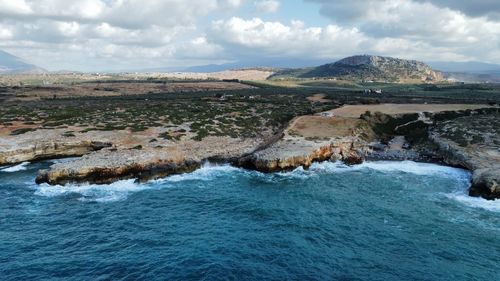 Scenic view of sea and mountains against sky