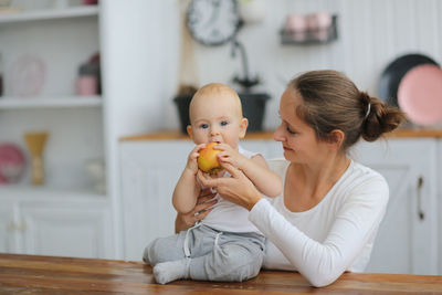 Portrait of smiling young woman holding apple
