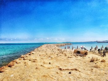 Scenic view of beach against blue sky