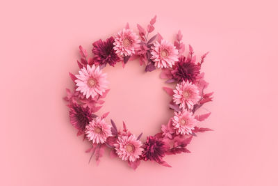 Directly above shot of christmas decorations against pink background