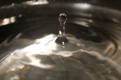 Close-up of drop falling on water surface