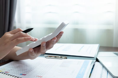 Midsection of man using mobile phone on table