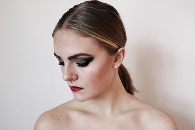 Portrait of young woman against white background