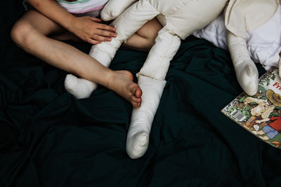 Low section of woman relaxing on bed