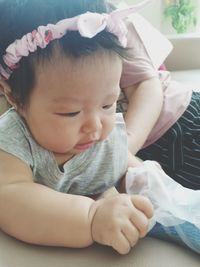 Cute baby girl lying on bed at home